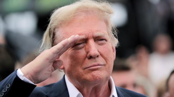 Former President Do<em></em>nald Trump salutes during opening ceremo<em></em>nies as he attends the NASCAR Coca-Cola 600 auto race, Sunday, May 26, 2024, in Concord, N.C. It is the first time that a president or former president has attended a race at Charlotte Motor Speedway. (AP Photo/Chris Seward)