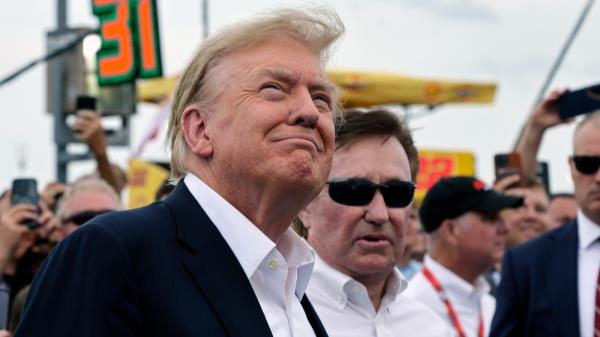 Former President Do<em></em>nald Trump smiles as a military jet does a flyover while he attends the NASCAR Coca-Cola 600 auto race, Sunday, May 26, 2024, in Concord, N.C. It is the first time that a president or former president has attended a race at Charlotte Motor Speedway. (AP Photo/Chris Seward)