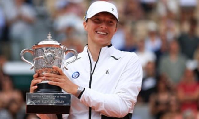 Iga Swiatek lifts the Suzanne-Lenglen Cup after winning the women’s singles final match at the 2023 French Open on 10 June 2023.