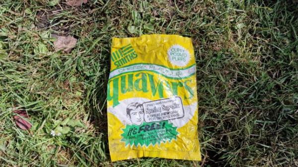 BNPS.co.uk (01202 558833) Pic: CenkAlbayrak-Touy?/BNPS A homeowner was stunned when he dug up a 49-year-old packet of Quavers crisps in his back garden. Cenk Albayrak-Touye was renovating his home in Poole, Dorset, when he made the discovery. He spotted the perfectly-intact yellow and green packet for the 'curly potato puffs' snack that were made by the British company Smiths Crisps at the time. The packet had the date of 31 October 1975 printed on it, which me<em></em>taed to a competition. Cenk, a 28-year-old English teacher, also found an old beer bottle for Dorchester brewery Eldridge Pope in his garden.