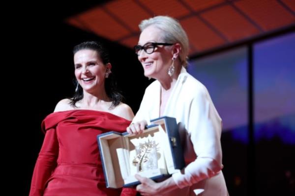 Meryl Streep (R) receives the Ho<em></em>norary Palme D’Or Award from Juliette Binoche (L) on stage during the opening ceremony at the 77th annual Cannes Film Festival at Palais des Festivals 