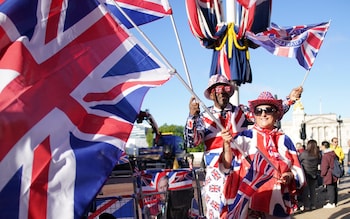 Royal fans gather on The Mall waving flags and dressed in red, white and blue