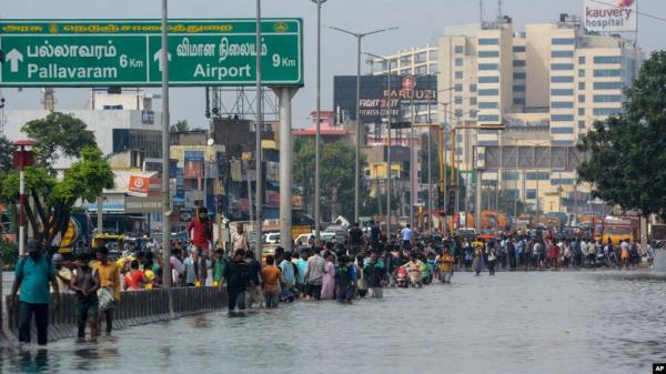 People wade through a flooded street following heavy rains along the Bay of Bengal coast in Chennai, India, Dec.5, 2023, as cyclone Michaung made landfall along the country's southeastern coastline.