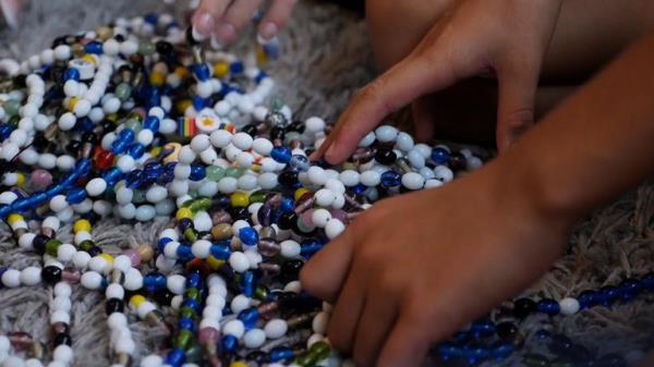 Oliver Chapman, 11, showing his beads which he tracks his cancer treatments with