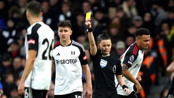 Referee Rebecca Welch (centre right) shows a yellow card to Fulham's Calvin Bassey (not pictured) for unsporting behaviour during the Premier League match at Craven Cottage, London. Picture date: Saturday December 23, 2023.