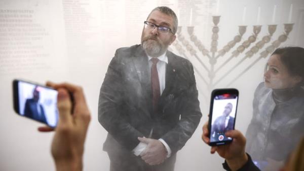 Grzegorz Braun, a member of the far-right Co<em></em>nfederation party is seen after using a fire extinguisher on to put out candles on a menorah that was lit during Hannukah celebration in the parliament building in Warsaw, Poland on December 12, 2023.