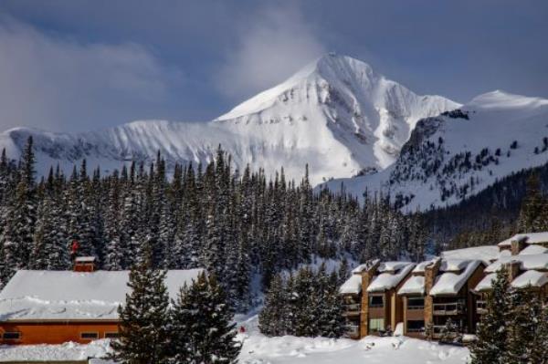 Snow-covered cabins and mountains at Montana's Big Sky Resort.