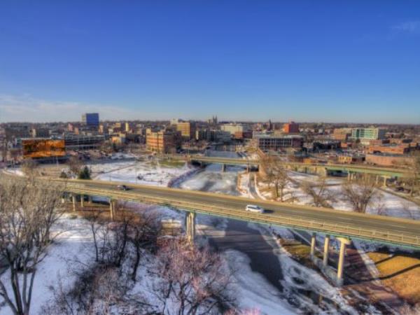 cityscape photo of shop, railroad track, and train in downtown Fargo, North Dakota in the snow