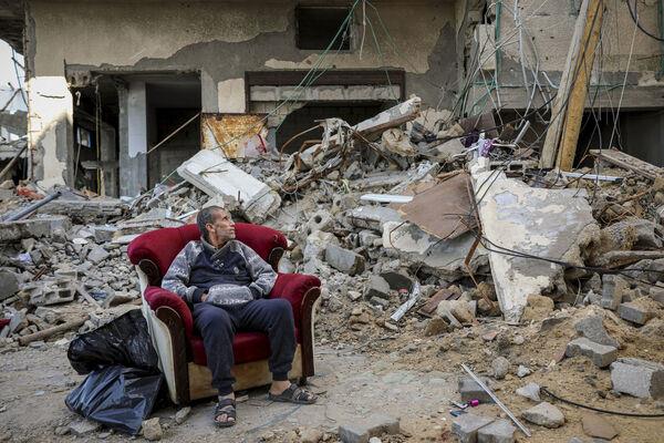 A Palestinian man sits in an armchair outside a destroyed building in Gaza City on Wednesday, Nov. 29, 2023, the sixth day of the temporary ceasefire between Hamas and Israel. Picture: AP Photo/Mohammed Hajjar