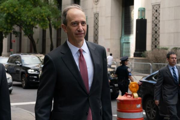 Abbe Lowell in a suit walking near a court