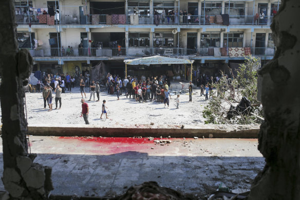 Palestinians look at the aftermath of the Israeli strike.