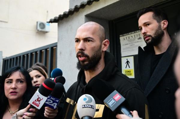 British-US former professio<em></em>nal kickboxer and co<em></em>ntroversial influencer Andrew Tate (C) and his brother Tristan Tate (R) speak to journalists after havin<em></em>g been released from detention in Bucharest, Romania