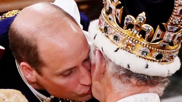 William, the Prince of Wales kisses his father King Charles III during his coro<em></em>nation ceremony 