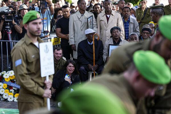 Family and friends of Staff Sergeant Aschalwu Sama mourn during his funeral in Petah Tikva, Israel, Sunday, Dec. 3, 2023. Sama, 20, died of his wounds after he was injured in a ground operation in the Gaza Strip. (AP Photo/Ariel Schalit)