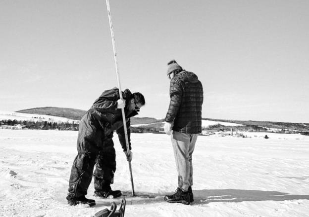 two men on ice ice fishing