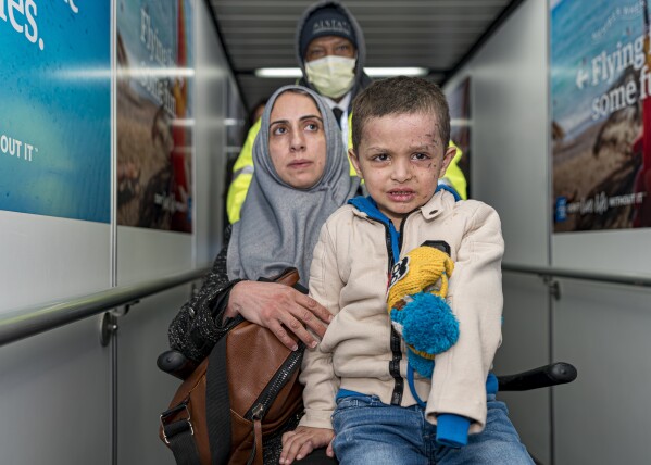 Four-year-old Omar Abu Kuwaik and his aunt Maha Abu Kuwaik, both from Gaza, are escorted through John F. Kennedy Internatio<em></em>nal Airport after departing a flight from Egypt on Wednesday, Jan. 17, 2024, in New York. Through the efforts of family and strangers, Omar was brought out of Gaza and to the United States, wher<em></em>e he received treatment, including a prosthetic arm. (AP Photo/Peter K. Afriyie)