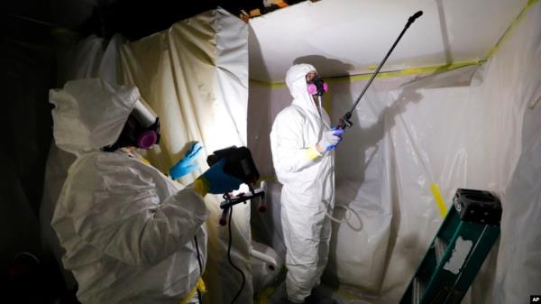 FILE - A crew works on asbestos abatement in Howell, Mich., Oct. 18, 2017. The Enviro<em></em>nmental Protection Agency on March 18, 2024, announced a ban on asbestos, a carcinogen that is still used in some chlorine bleach, brake pads and other products.