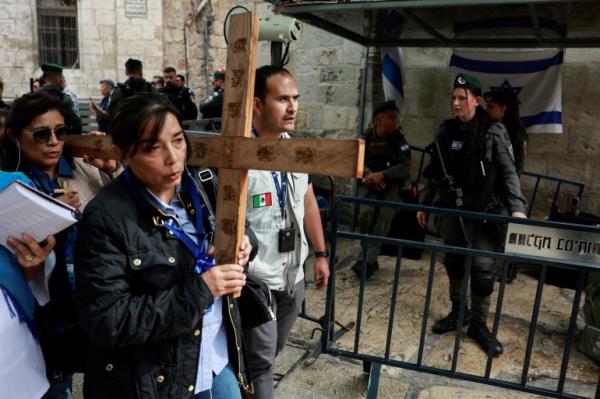 Worshippers carry a cross as they participate in the Good Friday procession at the Via Dolorosa in Jerusalem's Old City