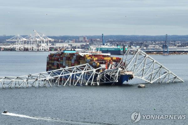 The steel f<em></em>rame of the Francis Scott Key Bridge sits on top of a co<em></em>ntainer ship after the bridge collapsed in Baltimore, Maryland, on March 26, 2024 in this photo released by AFP. (Yonhap)