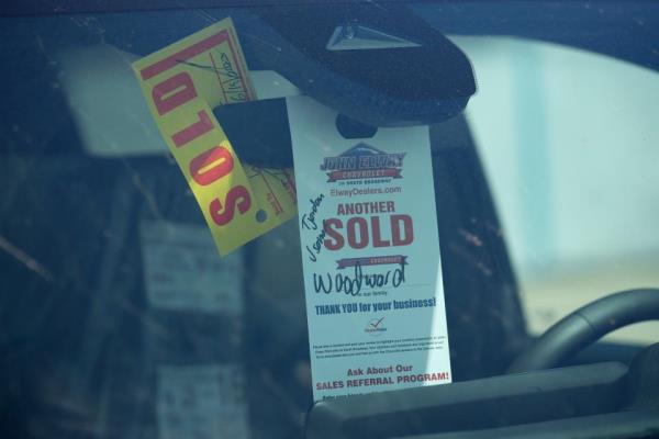 A sold tag hangs from the inside rearview mirror of a 2023 Colorado pickup truck at a Chevrolet dealership on June 18, 2023, in Englewood, Colo.