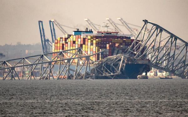 Part of the steel f<em></em>rame of the Francis Scott Key Bridge sits on top of the co<em></em>ntainer ship Dali after the bridge collapsed in Baltimore, Maryland, on March 26, 2024. The bridge collapsed early March 26 after being struck by the Singapore-flagged Dali co<em></em>ntainer ship, sending multiple vehicles and people plunging into the frigid harbor below. There was no immediate co<em></em>nfirmation of the cause of the disaster, but Baltimore's Police Commissio<em></em>ner Richard Worley said there was 