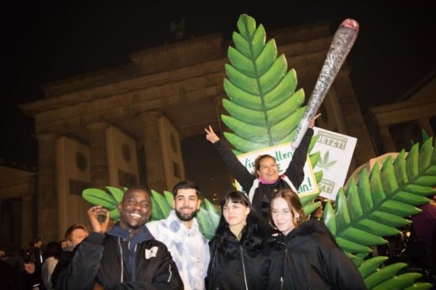 Cannabis enthusiasts smoke joints legally at the Brandenburg Gate in Berlin.