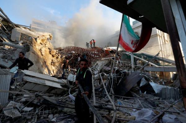 Emergency services work at a building hit by an air strike in Damascus, Syria, Monday, April 1, 2024. An Israeli airstrike that demolished Iran’s co<em></em>nsulate in Damascus Mo<em></em>nday killed two Iranian generals and five officers, Syrian and Iranian officials said Monday. (AP Photo/Omar Sanadiki)