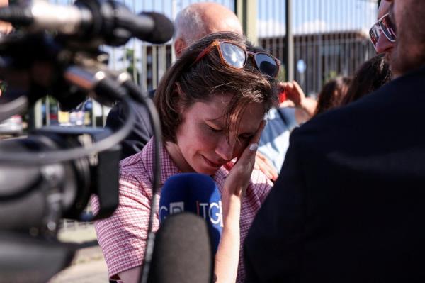 Amanda Knox with her eyes closed reacting to the verdict in the slander case at Italy Court in Florence, speaking into a microphone