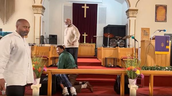 Pastor presses his hands together while delivering sermon