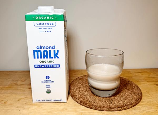 almond malk co<em></em>ntainer with a glass of almond malk 