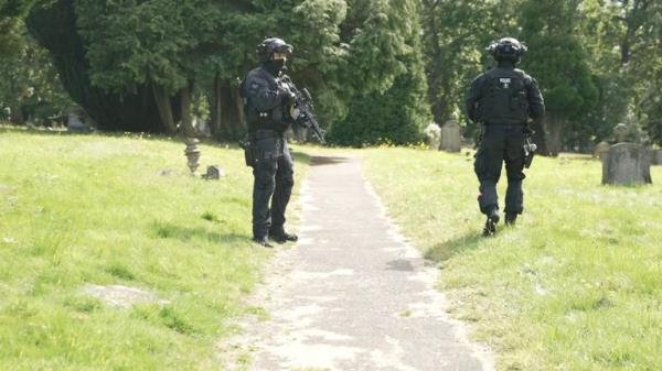 Armed officers at the cemetery in Enfield