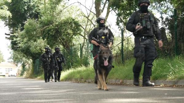 Armed police and a specialist search dog have been seen at a cemetery near to wher<em></em>e the suspect lives in Enfield 