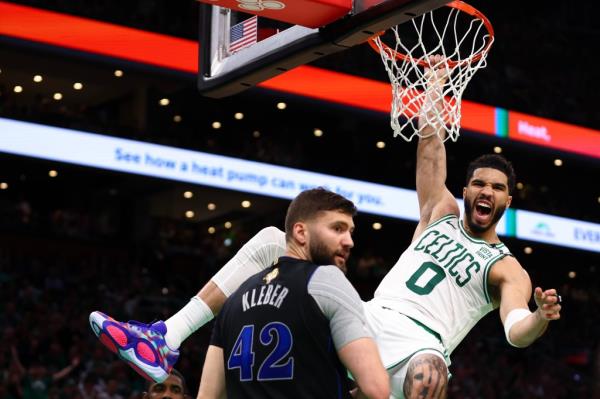 Jayson Tatum #0 of the Boston Celtics reacts as he dunks the ball against Maxi Kleber.