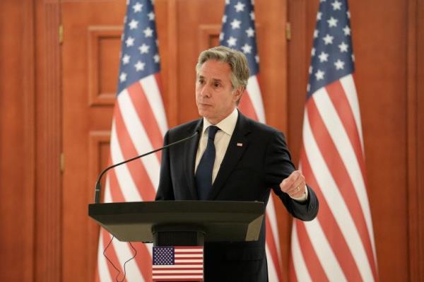 Antony Bl<em></em>inken with three US flags behind him