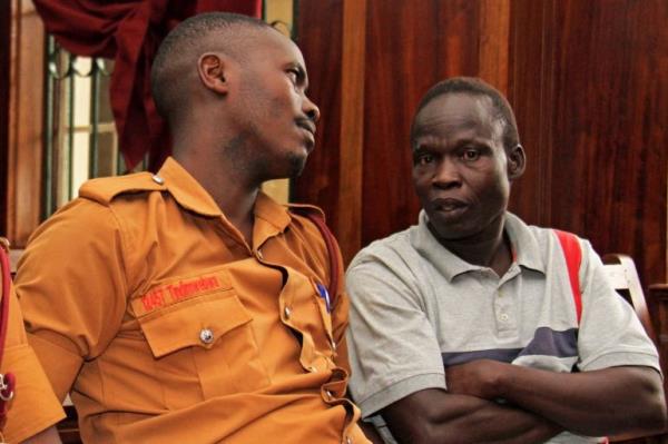 Suspected LRA (Lords Resistance Army) member Thomas Kwoyelo (R) is pictured during a pre-trial session at the High Court in Kampala on Februay 1, 2017. Kwoyelo is indicted on 93 counts including murder, rape, defilement, destruction of crops and property, recruitment of children as soldiers and other crimes against humanity which were allegedly committed as one of the Lord Resistance Army (LRA) commanders during the 20 years of political insurgency in northern Uganda. (Photo by GAEL GRILHOT / AFP)