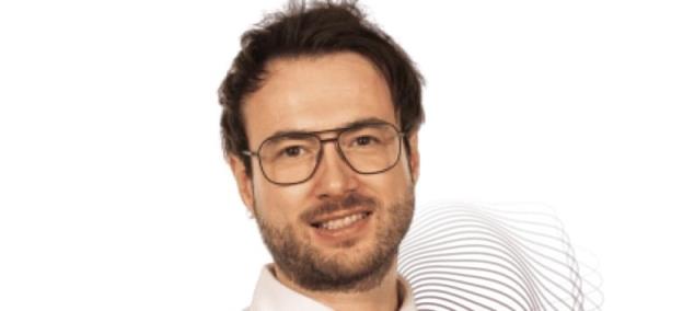 A portrait of a young man with glasses.