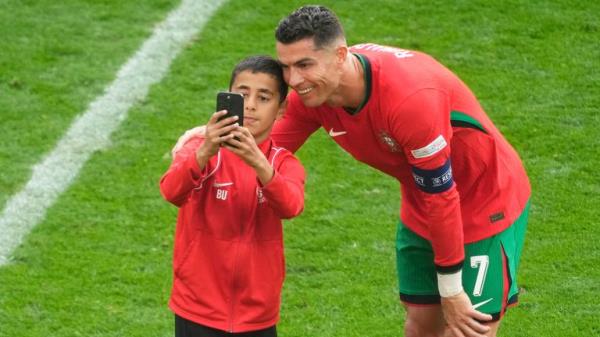 A young pitch invader takes a selfie with Portugal's Cristiano Ro<em></em>naldo during a Group F match between Turkey and Portugal at the Euro 2024 soccer tournament in Dortmund, Germany, Saturday, June 22, 2024. (AP Photo/Michael Probst)