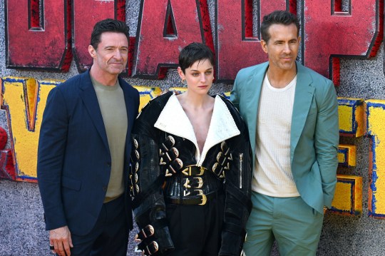 (L-R) Hugh Jackman, Emma Corrin and Ryan Reynolds pose on red carpet at Deadpool & Wolverine film sneak peek event in London