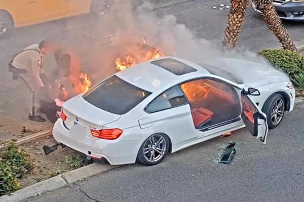 The men pull the driver from the car.