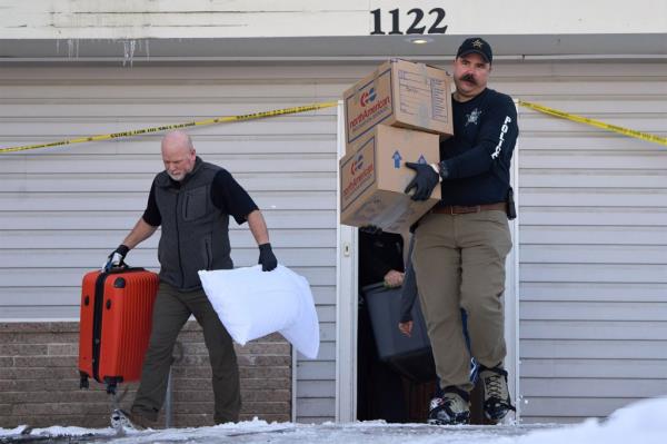 Police officers remove boxes and a suitcase from the home wher<em></em>e four college students were killed in Idaho.