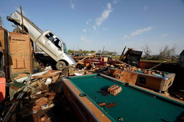 A pickup truck rests on top of a restaurant cooler at Chuck's Dairy Cafe, in the aftermath of tornadoes that tore through the state on Friday night