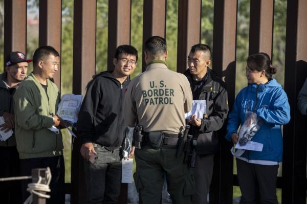 Migrants wait to be processed by US Border Patrol officers after they crossed in the US illegally, in Yuma, Arizona