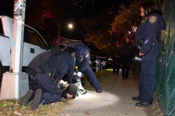 Police take a suspect into custody at the scene of a two vehicle accident.