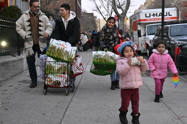 Rev. Juan Carlos Ruiz walks with Venezuelan family, Georgina Parades, Michael Corros  and their two daughters Keyle and Kata.