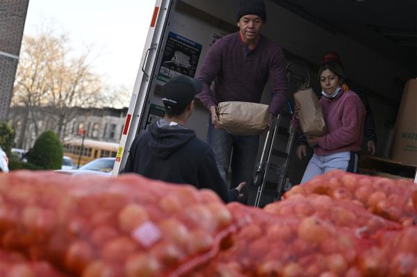 People unload food from a truck.