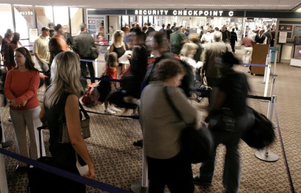 Airline passengers wait in line at a security checkpoint in terminal four at Phoenix Sky Harbor Internatio<em></em>nal Airport