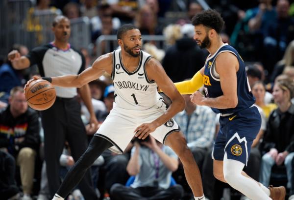 Mikal Bridges looks to drive to the basket as Denver Nuggets guard Jamal Murray defends.