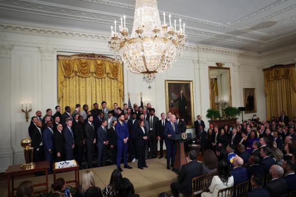 President Joe Biden holds up a Golden State Warriors jersey as Vice President Kamala Harris applauds on Jan. 17, 2023 in Washington, DC.