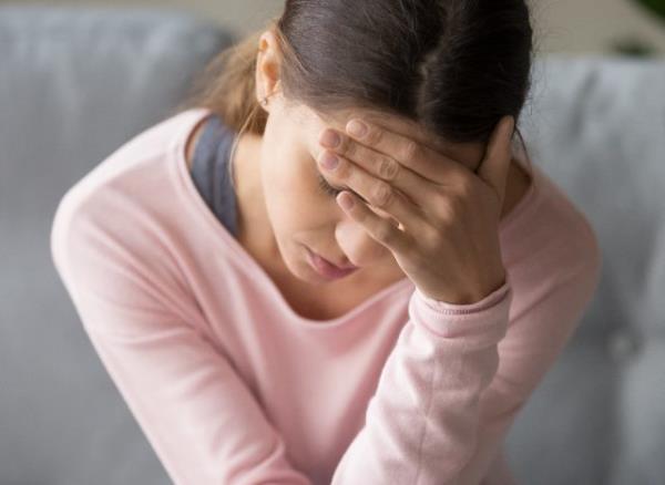 woman dealing with severe headache or migraine at home