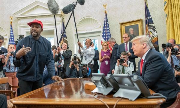 Kanye West stands as he talks with real estate developer and US President Do<em></em>nald Trump in the White House's Oval Office in Washington D.C. on Oct. 11, 2018. 